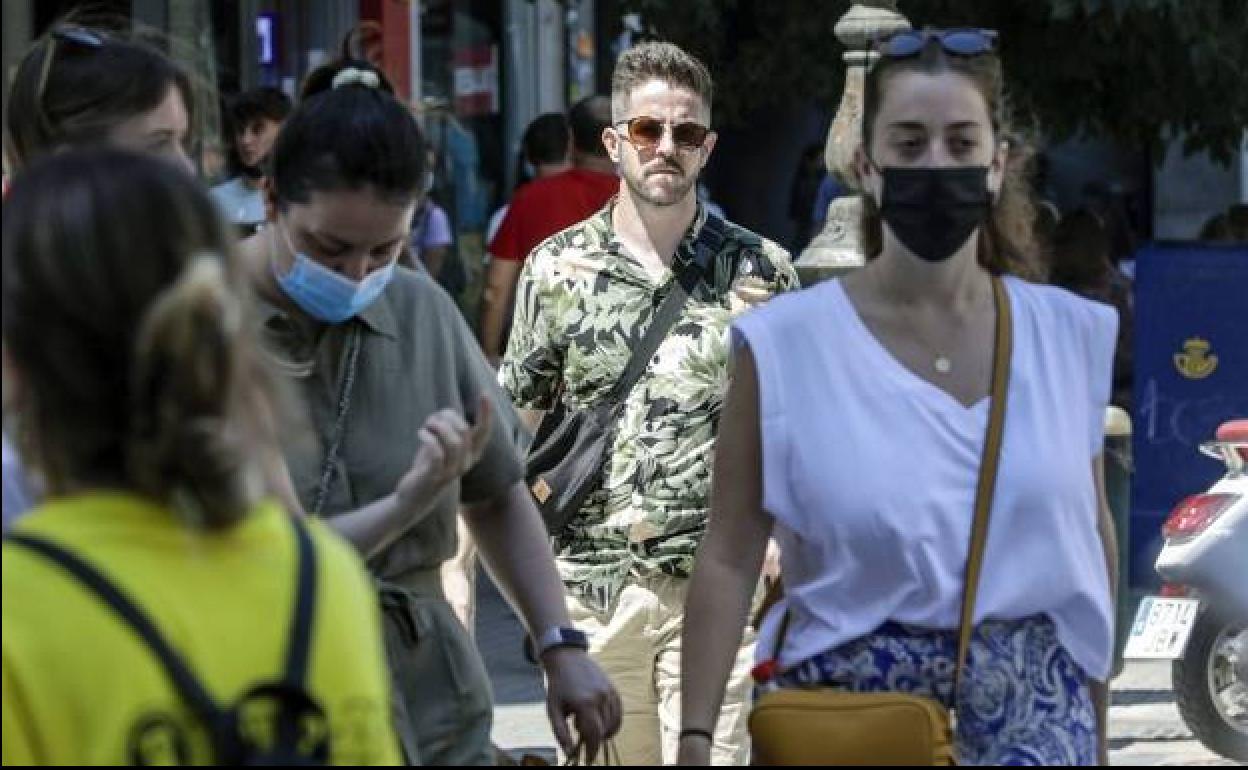 Gente paseando con mascarilla por la calle, en Valencia.