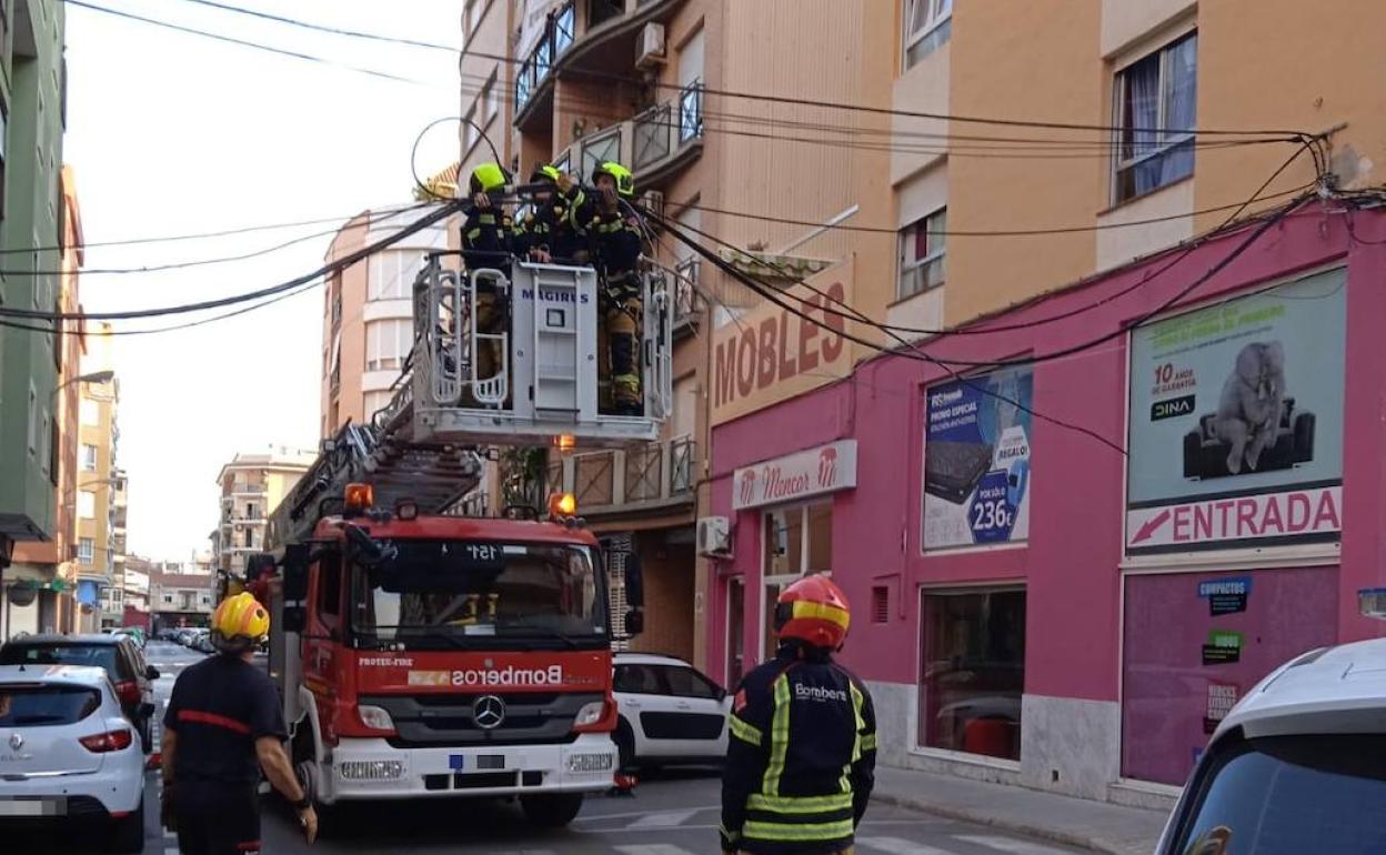 Los bomberos actuando en la zona donde se ha descolgado el cableado. 