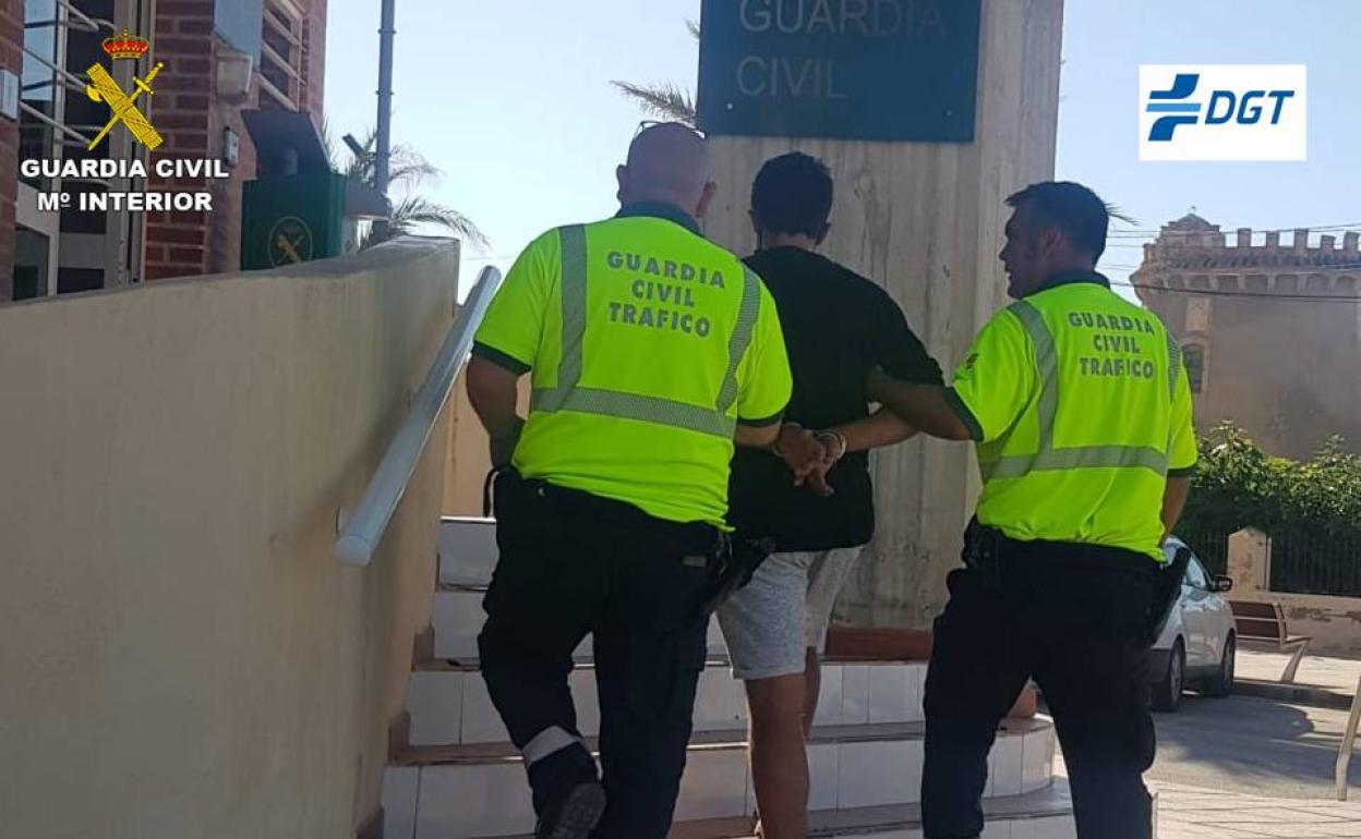 Dos agentes trasladan al detenido después de la persecución. 