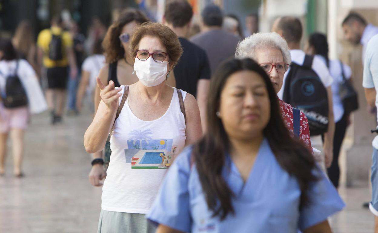 Personas con mascarilla paseando por el centro de Valencia. 