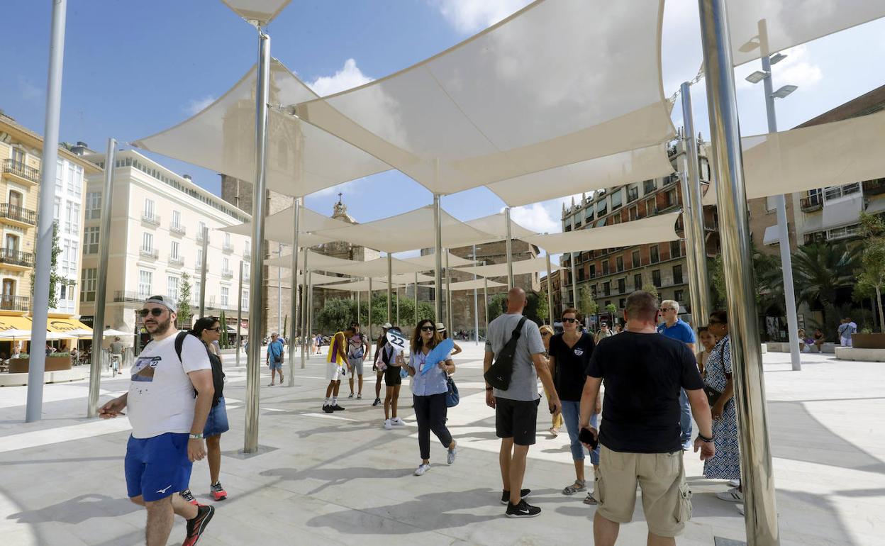 Valencianos y turistas visitina la nueva plaza de la Reina. 