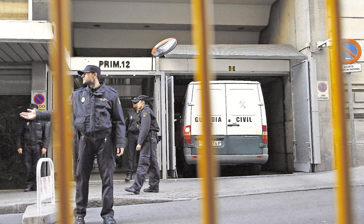 Policías Nacionales aguardan junto a un furgón en la puerta de la Audiencia Nacional. 