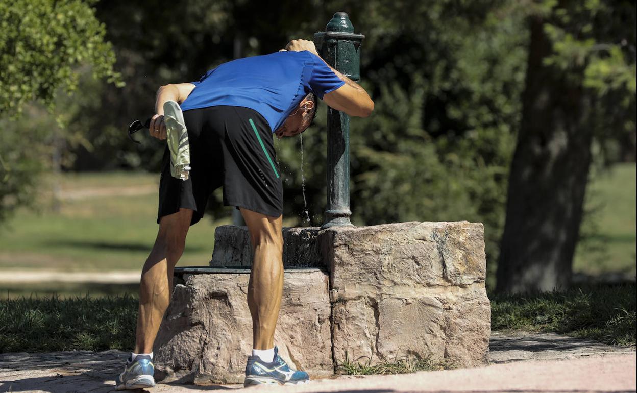 Imagen de archivo de un hombre refrescándose en Valencia ante las altas temperaturas