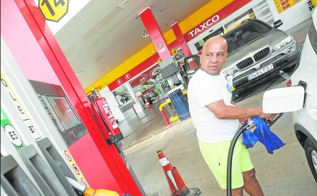 Un hombre pone gasolina en su coche en una estación de servicio.