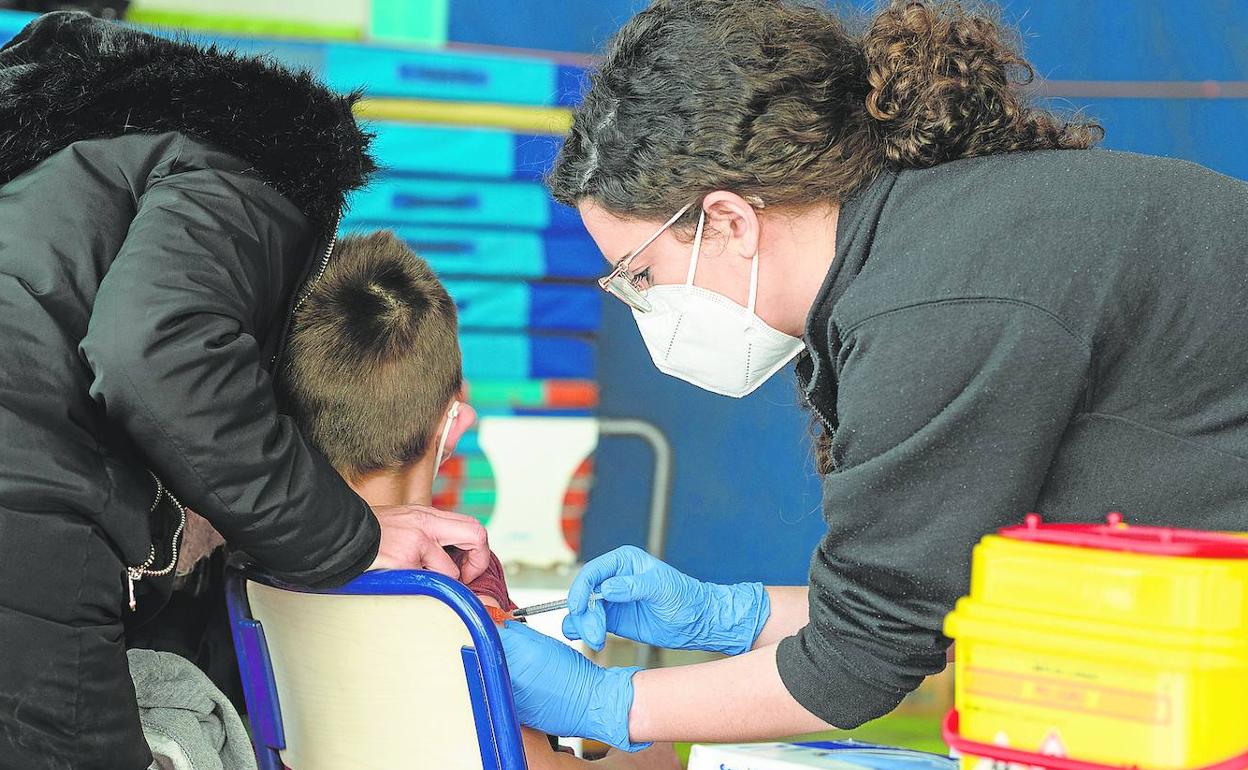 Personal sanitario vacuna contra el Covid a un niño en un colegio valenciano.