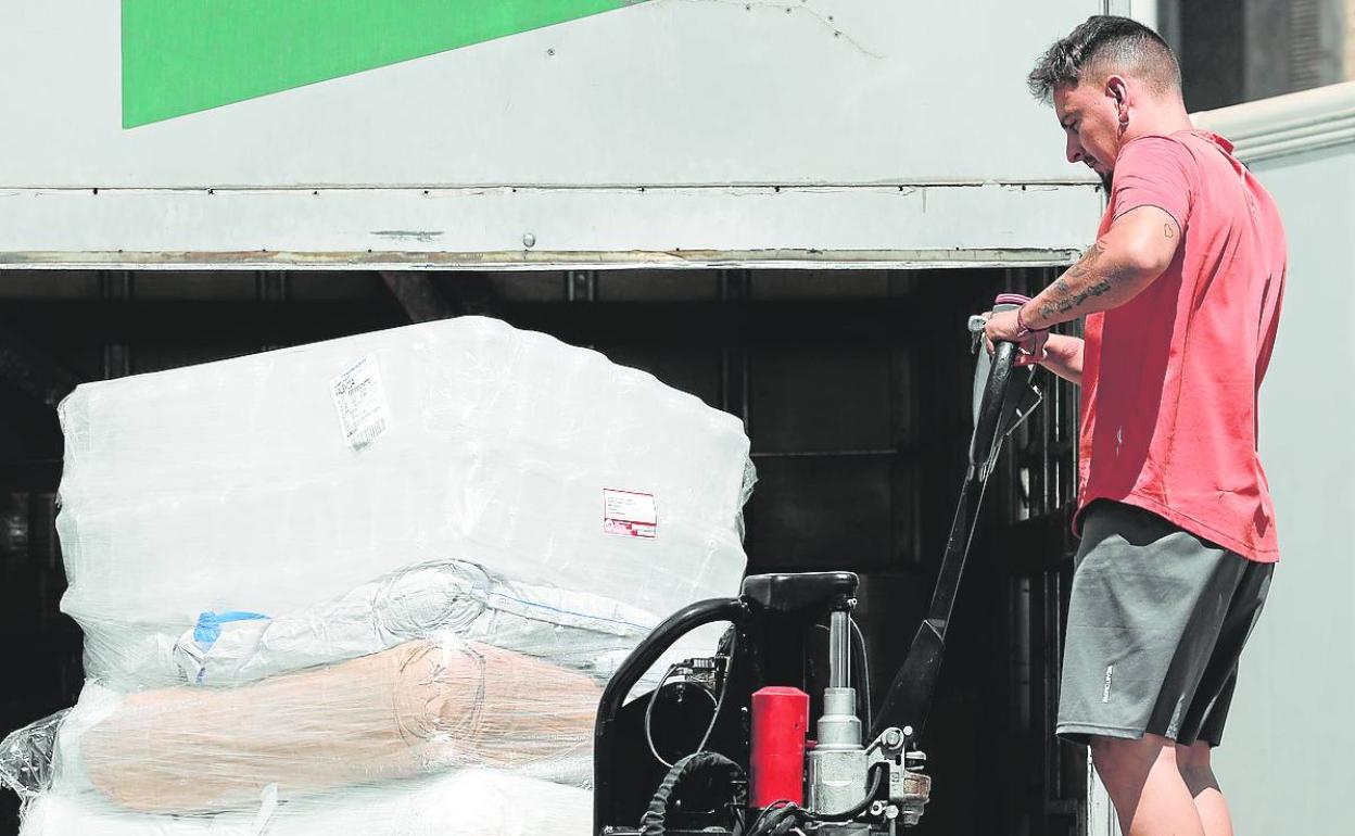 Un transportista carga mercancía en un comercio. 