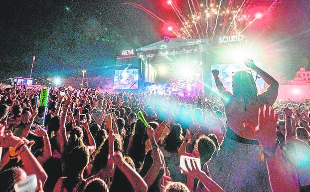 Los pasajeros paran un autobús sin aire acondicionado del Arenal Sound