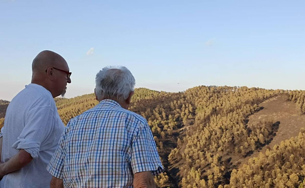 Dos hombres observan el paraje calcinado del Barranc de Malafi