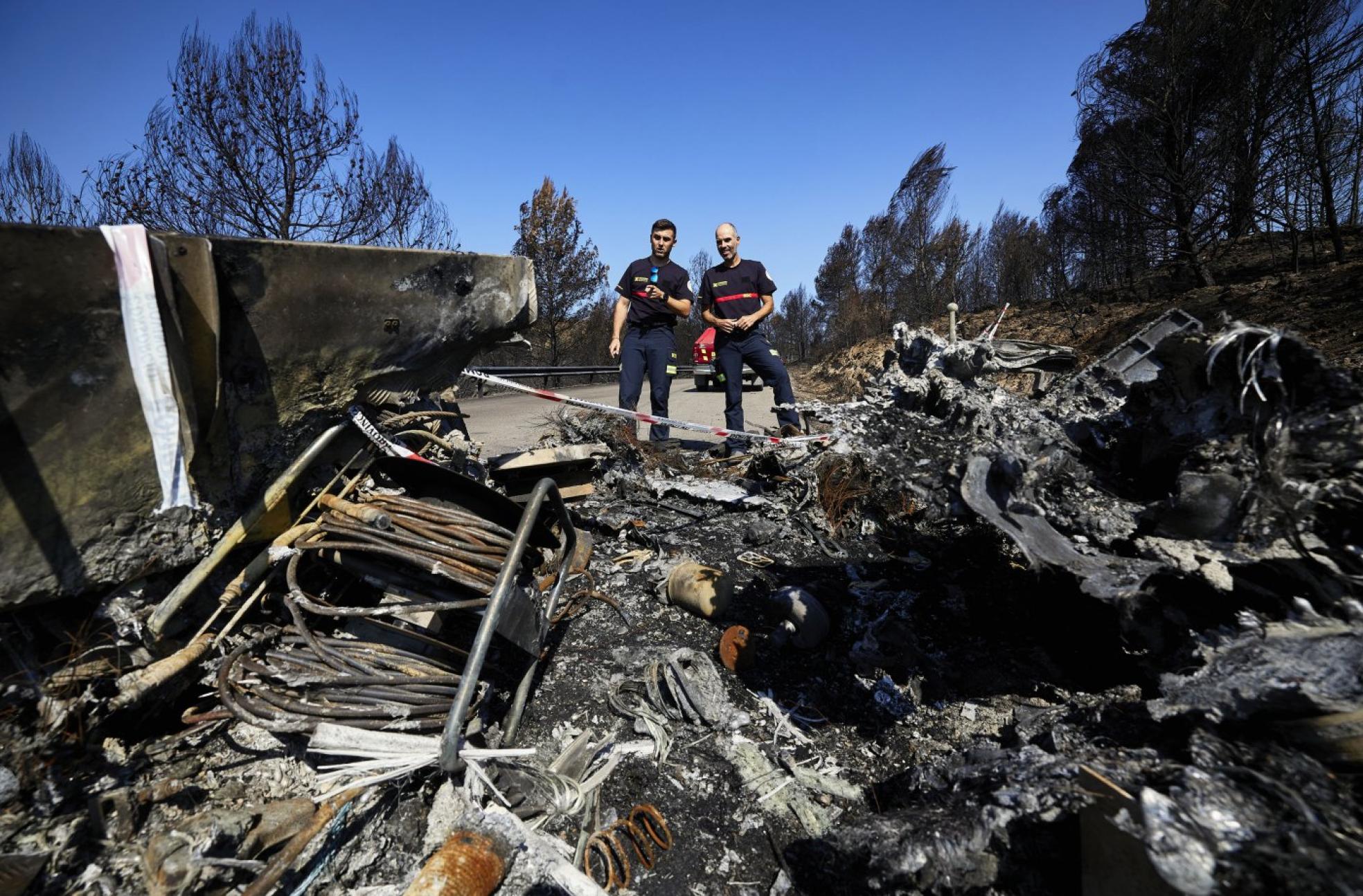Las víctimas de Torás. Andrés Villajos y David Pérez junto a los restos del camión destruido por el fuego.
