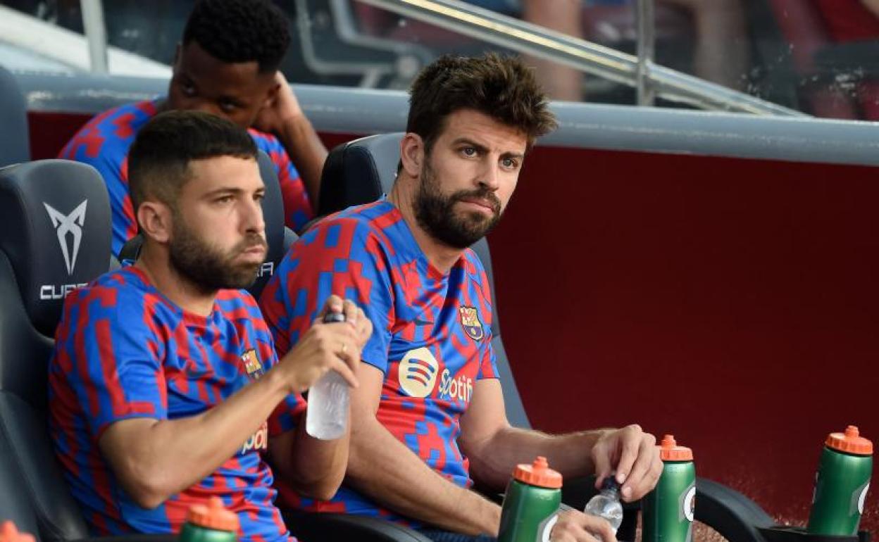 Jordi Alba y Gerard Piqué, sentados en el banquillo. 