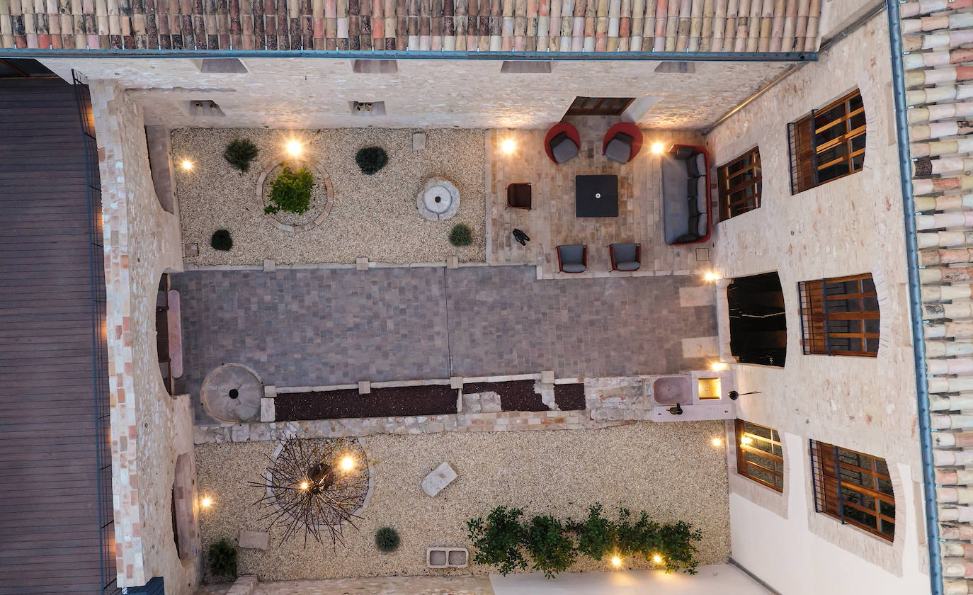 Vista aérea del patio de la casa, donde se aprecia el antiguo pozo y acequias reconvertidos en los elementos que ordenan y embellecen el espacio exterior.