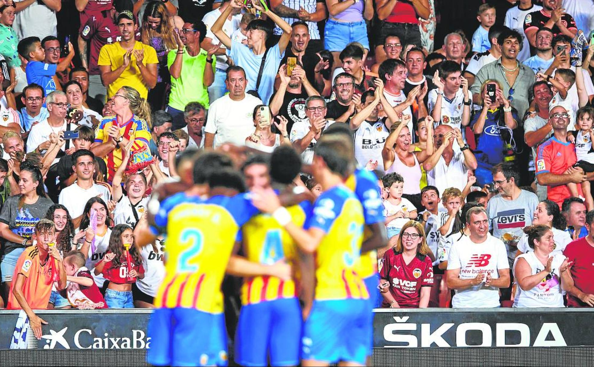 Aficionados aplauden tras un gol del Valencia.