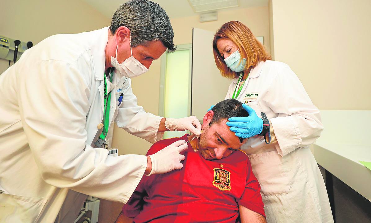 Hospital. El doctor Vázquez, neurólogo, inyecta toxina botulínica a Manuel para aliviar la rigidez muscular y los dolores que causa.