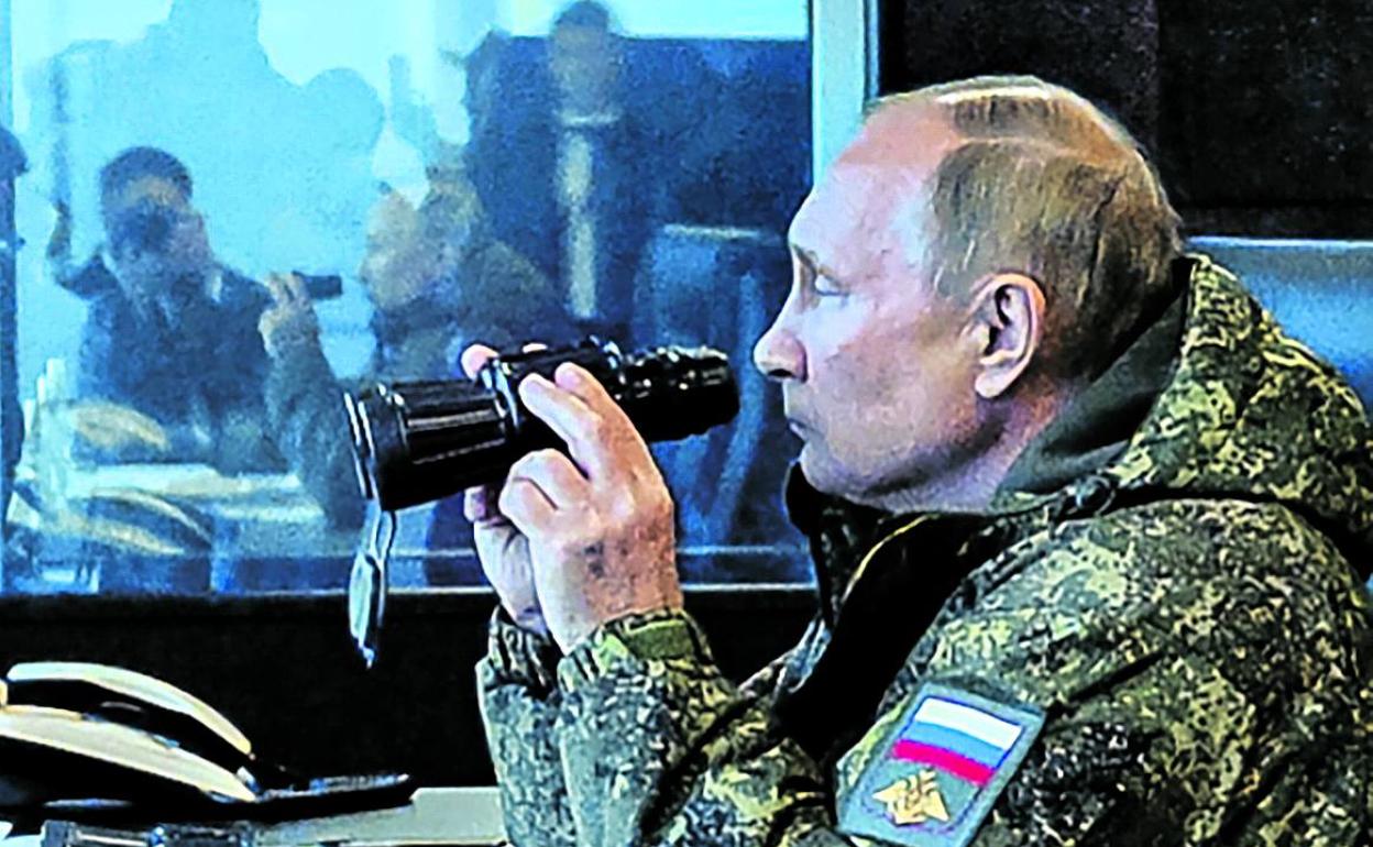 Vladímir Putin, con ropa de camuflaje, observa los ensayos militares Vostok-2022.