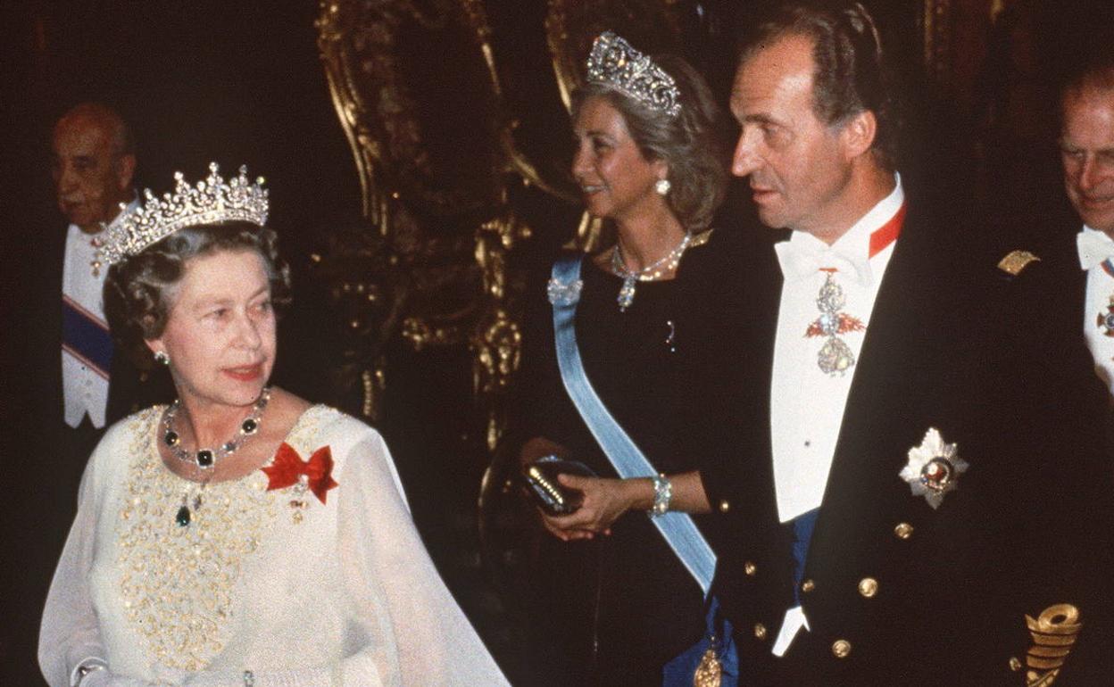 La reina Isabel II (izqda.) junto al rey emérito Juan Carlos I (drcha.) y la reina Sofía al fondo. 