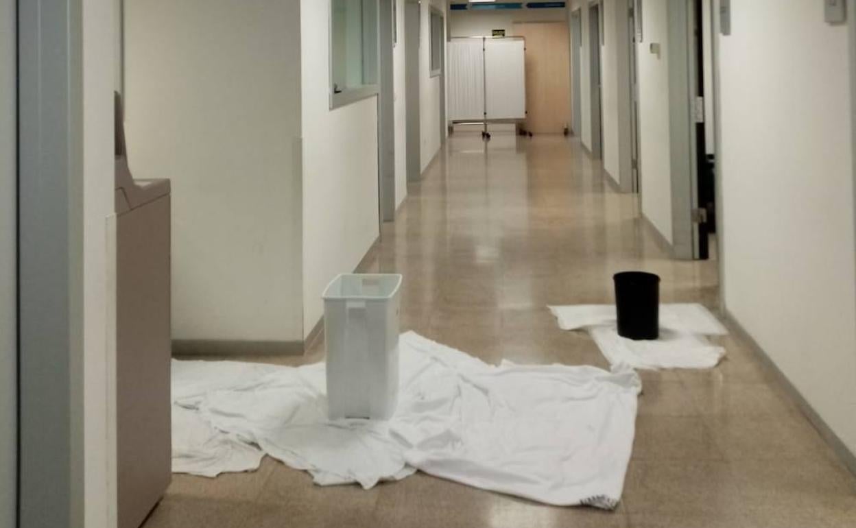 Cubos y toallas en el suelo de un pasillo del hospital La Fe. 