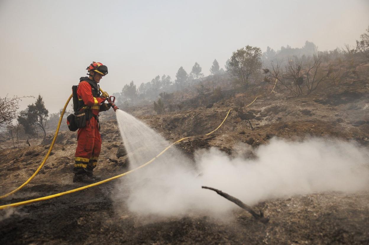 Bomberos luchan contra el incendio que se declaró en verano en Bejís y que dejó cercado un tren. 