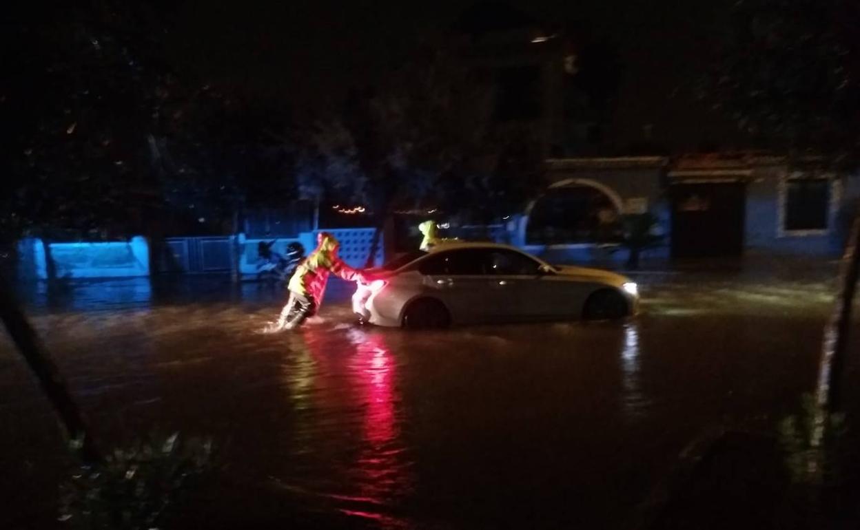 Empujan un coche que quedó parado en Dénia. 