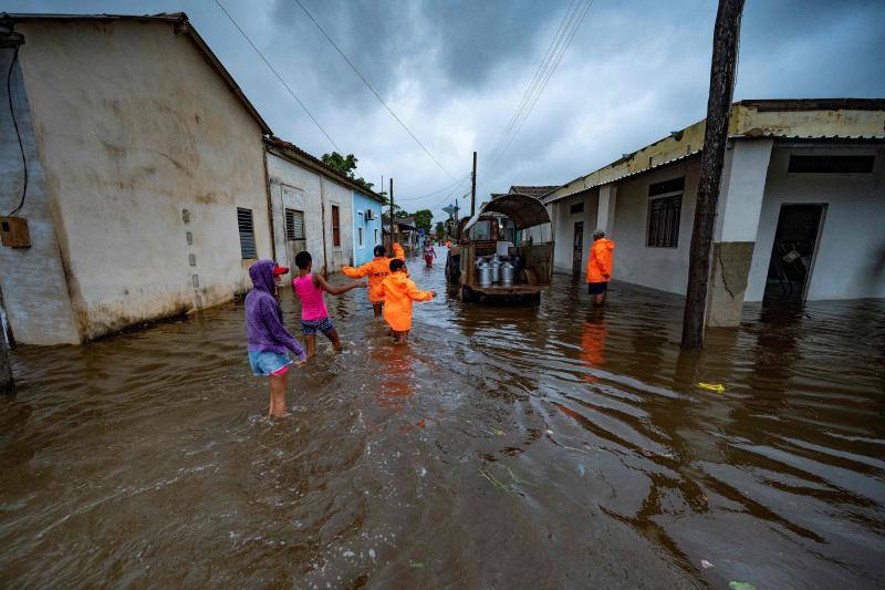 Un grupo de gente camina por las anegadas calles de Batabano. El huracán Ian ha provocado un apagón en toda la isla, así como inundaciones y destrozos.