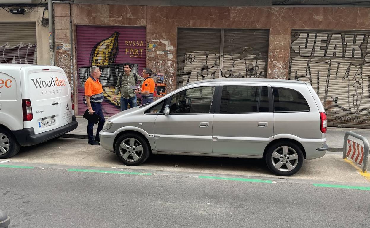 Un vecino pregunta a dos agentes de la ORA, este lunes en Ruzafa. 