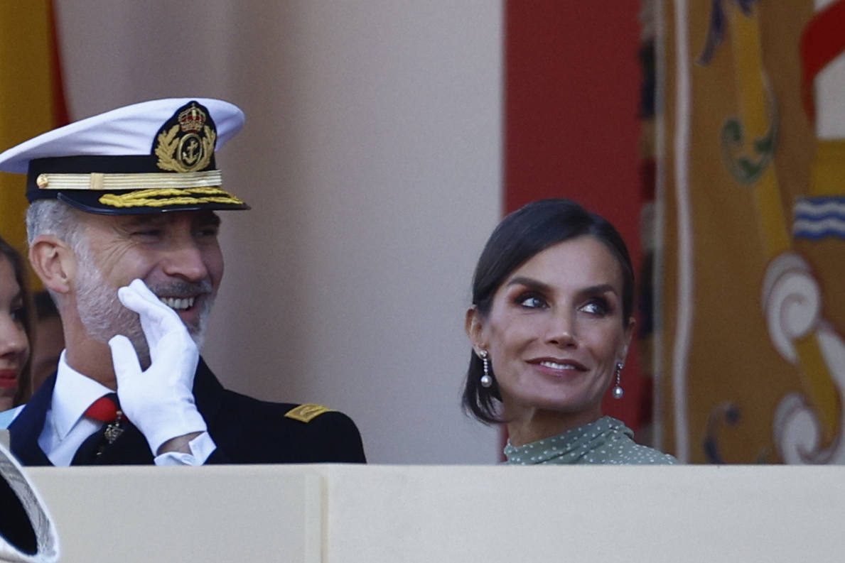 La reina opta por un vestido de gasa en verde con lunares blancos de la firma española Vogana. Se trata del modelo Nanda, de la colección del año 2021, con un precio de 265 euros. En la pieza de silueta fluida y cintura marcada destacaban las originales mangas, con una abertura que dejaba ver discretamente sus torneados brazos y formadan una suerte de capa. Menos discretos son los espectaculares pendientes de perlas australianas que le regaló don Felipe hace más de una década, con los que completó el estilismo.