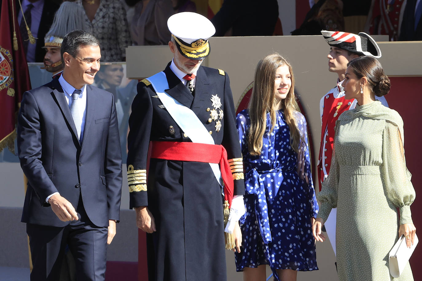 La reina opta por un vestido de gasa en verde con lunares blancos de la firma española Vogana. Se trata del modelo Nanda, de la colección del año 2021, con un precio de 265 euros. En la pieza de silueta fluida y cintura marcada destacaban las originales mangas, con una abertura que dejaba ver discretamente sus torneados brazos y formadan una suerte de capa. Menos discretos son los espectaculares pendientes de perlas australianas que le regaló don Felipe hace más de una década, con los que completó el estilismo.