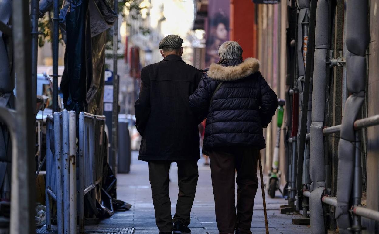 Dos pensionistas paseando por la calle.