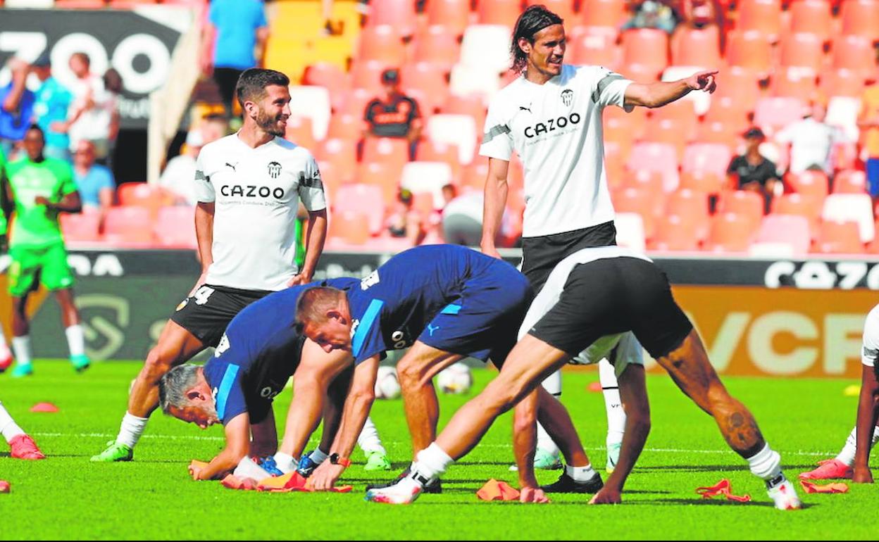 A punto. Cavani, que aparenta estar recuperado del tobillo, hace una indicacióna Gayà en el calentamiento del último partido.