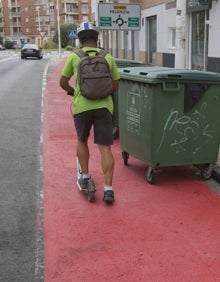 Imagen secundaria 2 - Los vecinos comentan entre ellos y dos patinetes circulan por el carril con obstáculos. 