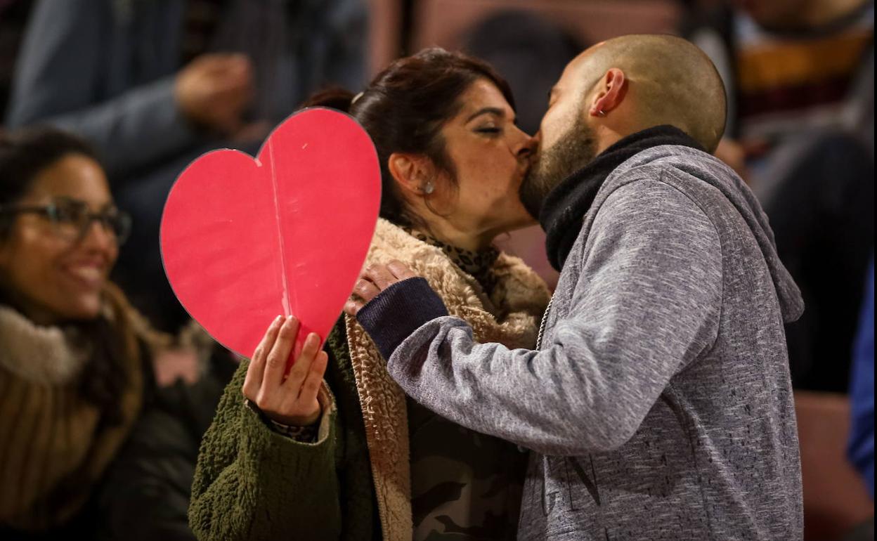 Una pareja se besa durante un partido de fútbol en Granada.