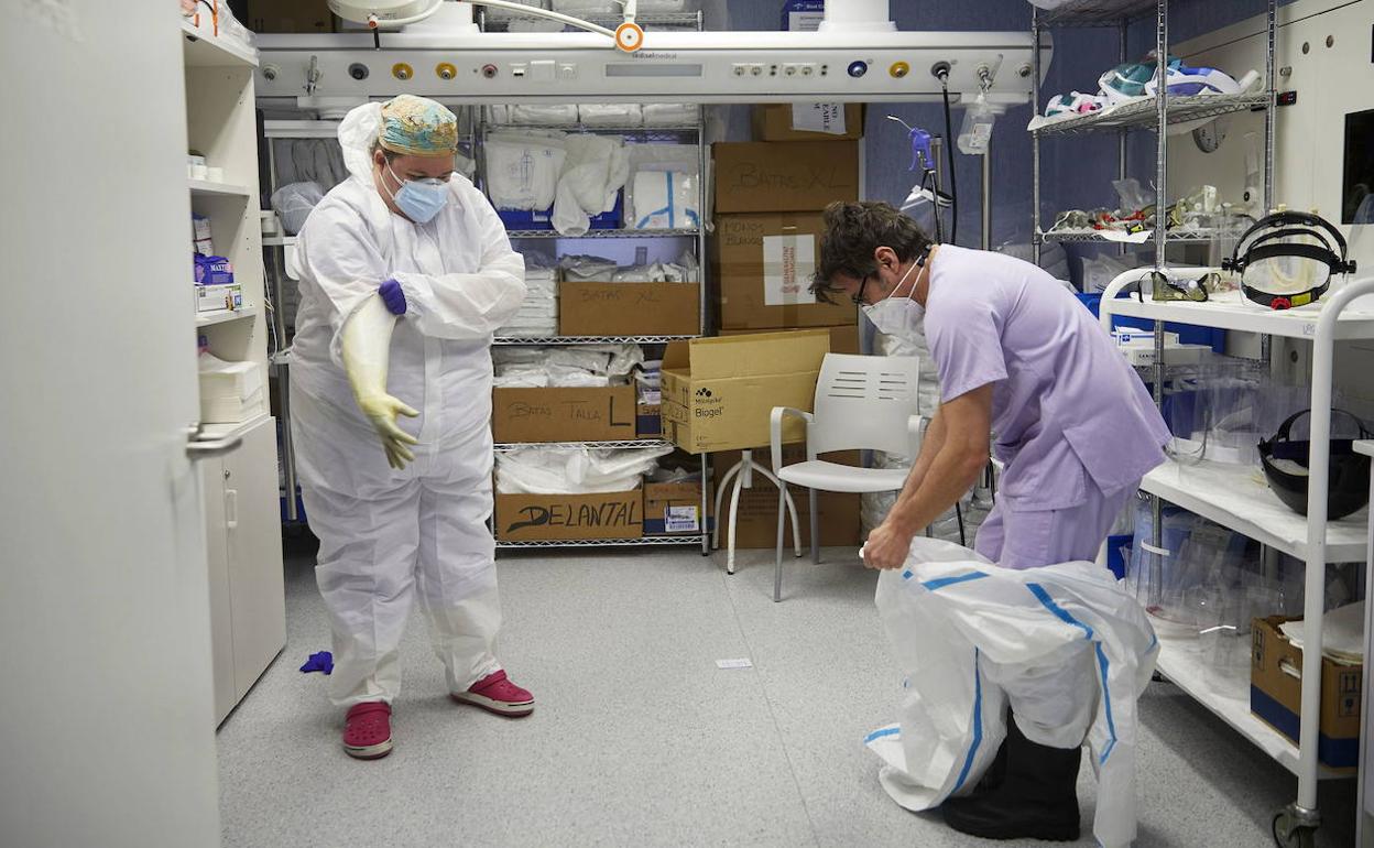 Personal sanitario se dota de equipos de protección en la UCI de un hospital valenciano.