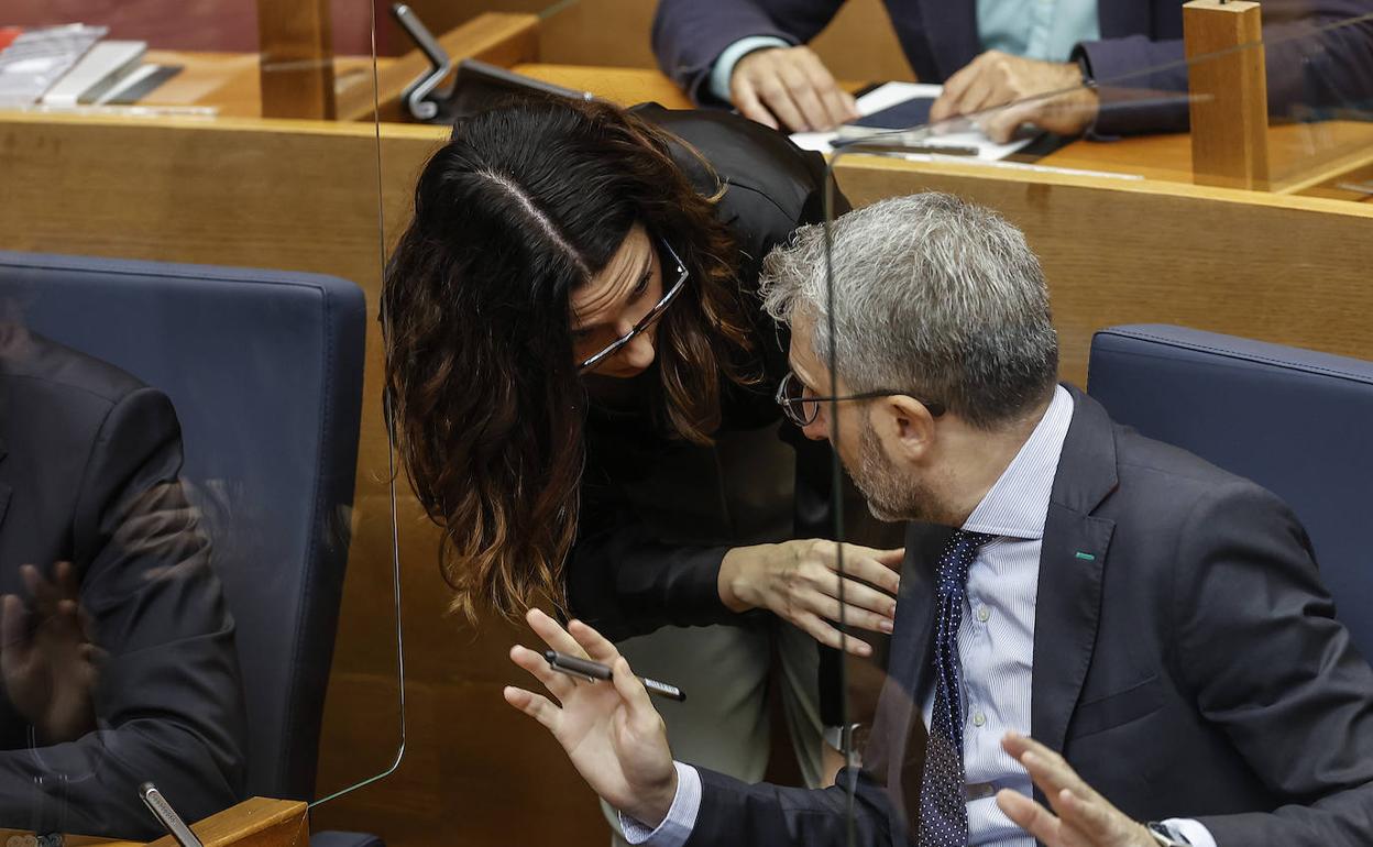 El conseller de Hacienda, Arcadi España, conversa en Les Corts con la vicepresidenta, Aitana Mas. 