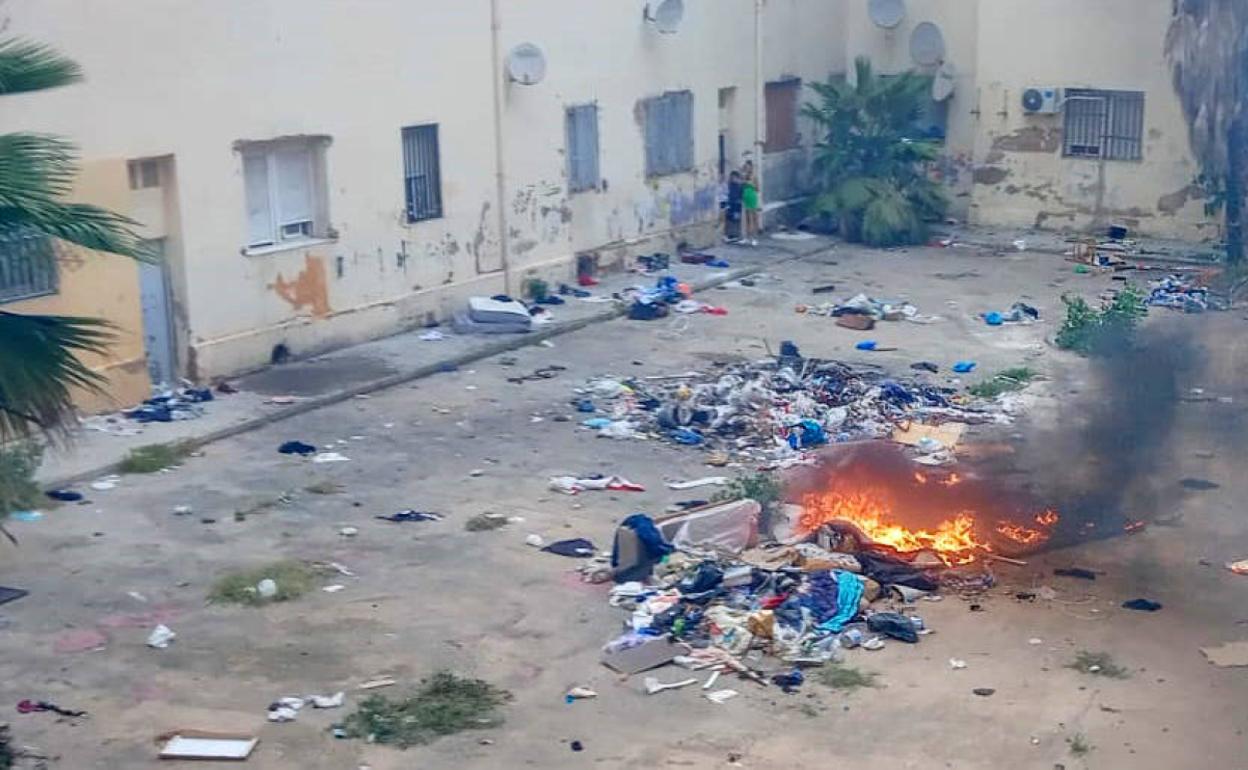 Hoguera con colchones, muebles y basura en un patio interior de las Casitas Rosa de la Malvarrosa. 