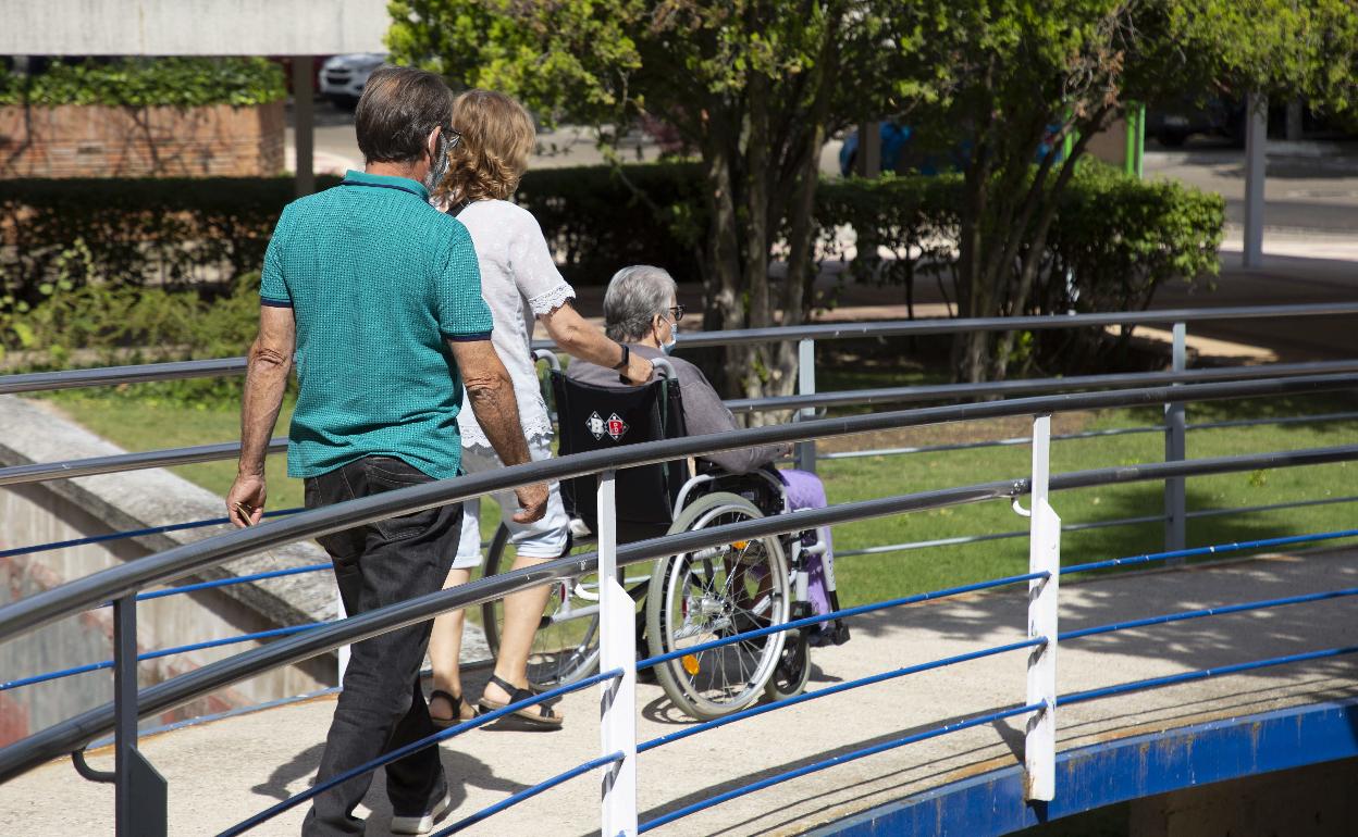 Familiares trasladan a una persona mayor durante una visita a una residencia, en una imagen de archivo. 