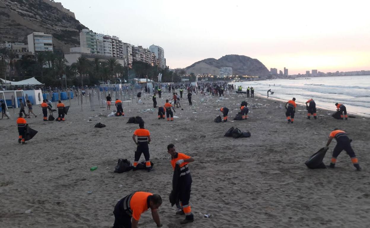 Empleados de la limpieza recogen residuos en El Postiguet. 