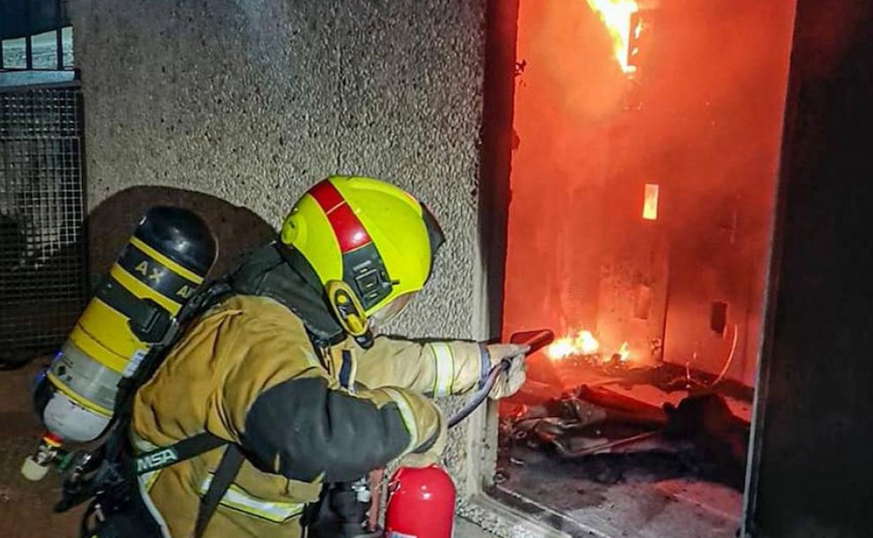 Un bombero sofoca las llamas del incendio con un extintor. 