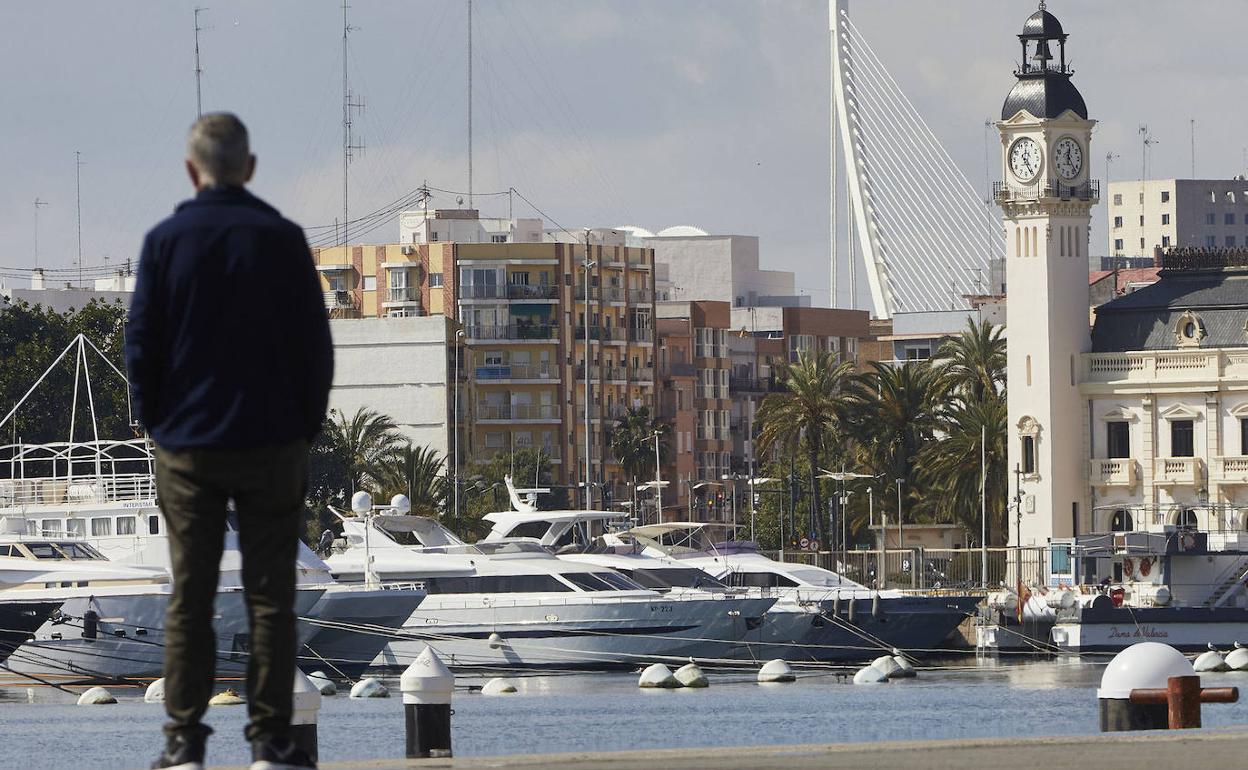 Un viandante contempla la dársena interior, con el edificio del Reloj al fondo. 