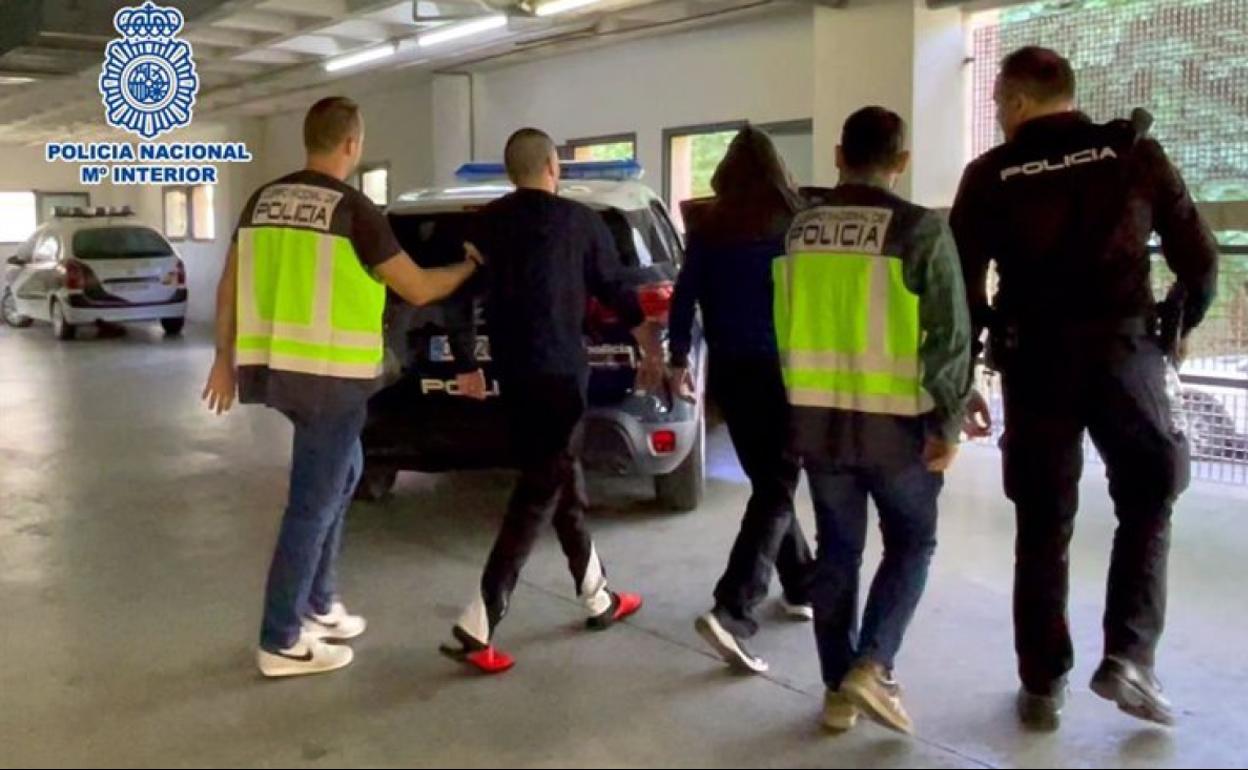 Dos agentes de la Policía Nacional acompañan a los dos detenidos. 