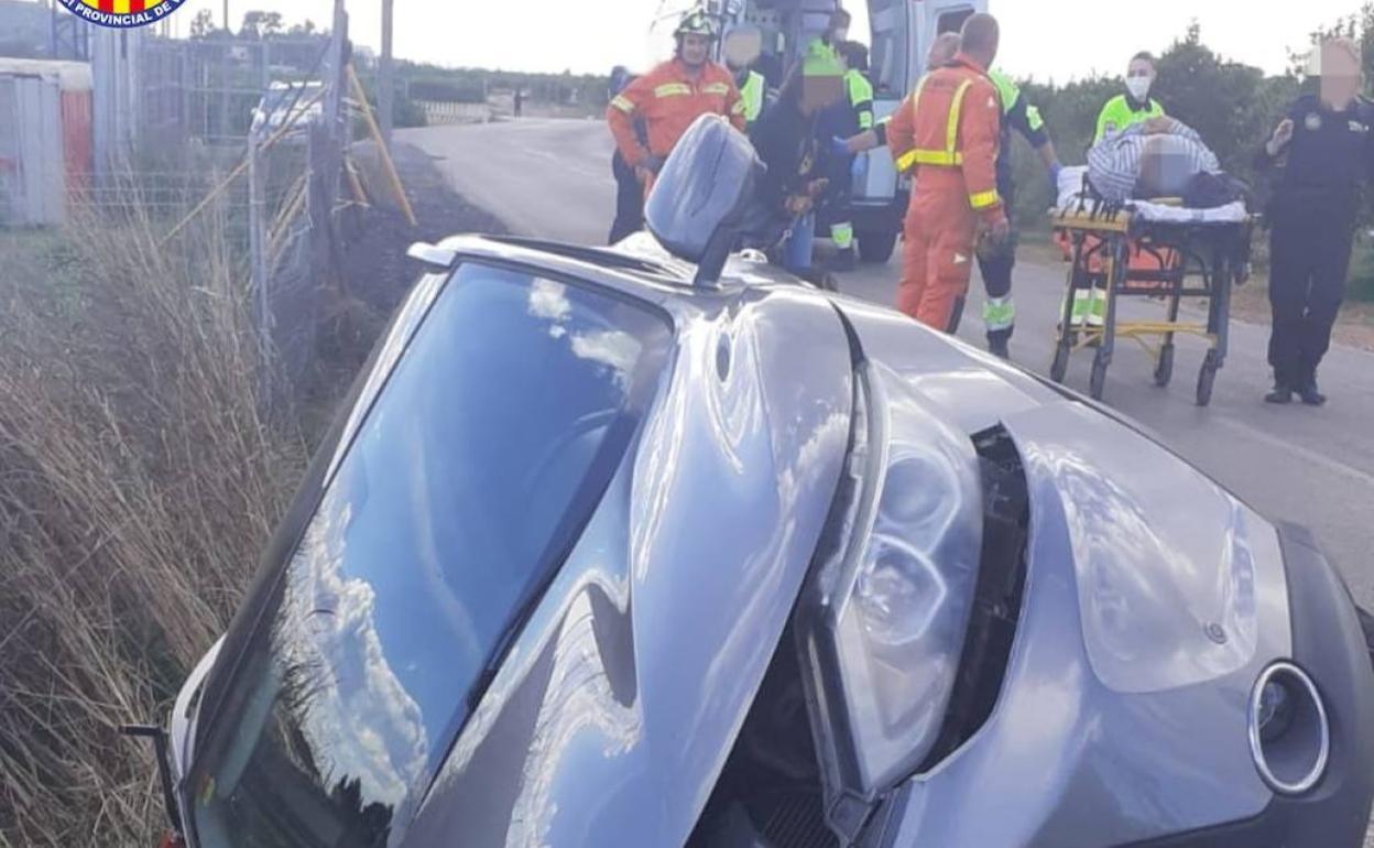 Los bomberos trasladan a los heridos del coche accidentado. 