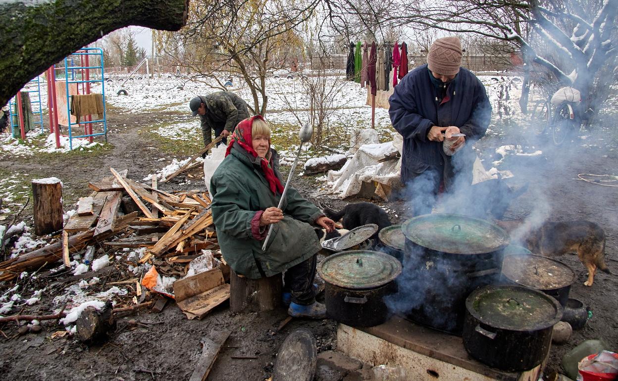 Una mujer cocina al aire libre delante de su hogar en Cherkaski Tishki, en la región de Járkov. 