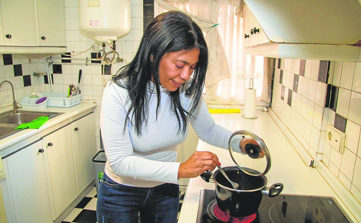 Lina, una madre en situación de apuros económicos, prepara una comida en la cocina de su casa en Valencia. 