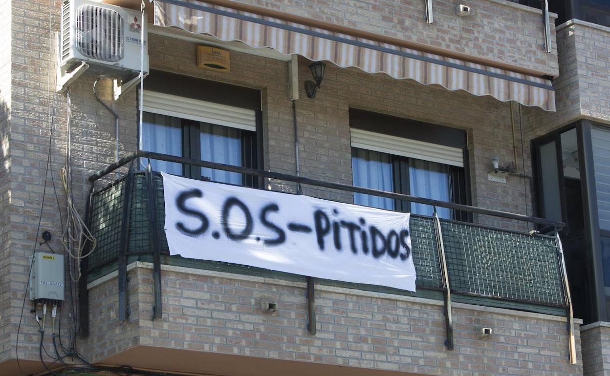 Una de las pancartas reivindicativas en un balcón junto a las vías. 