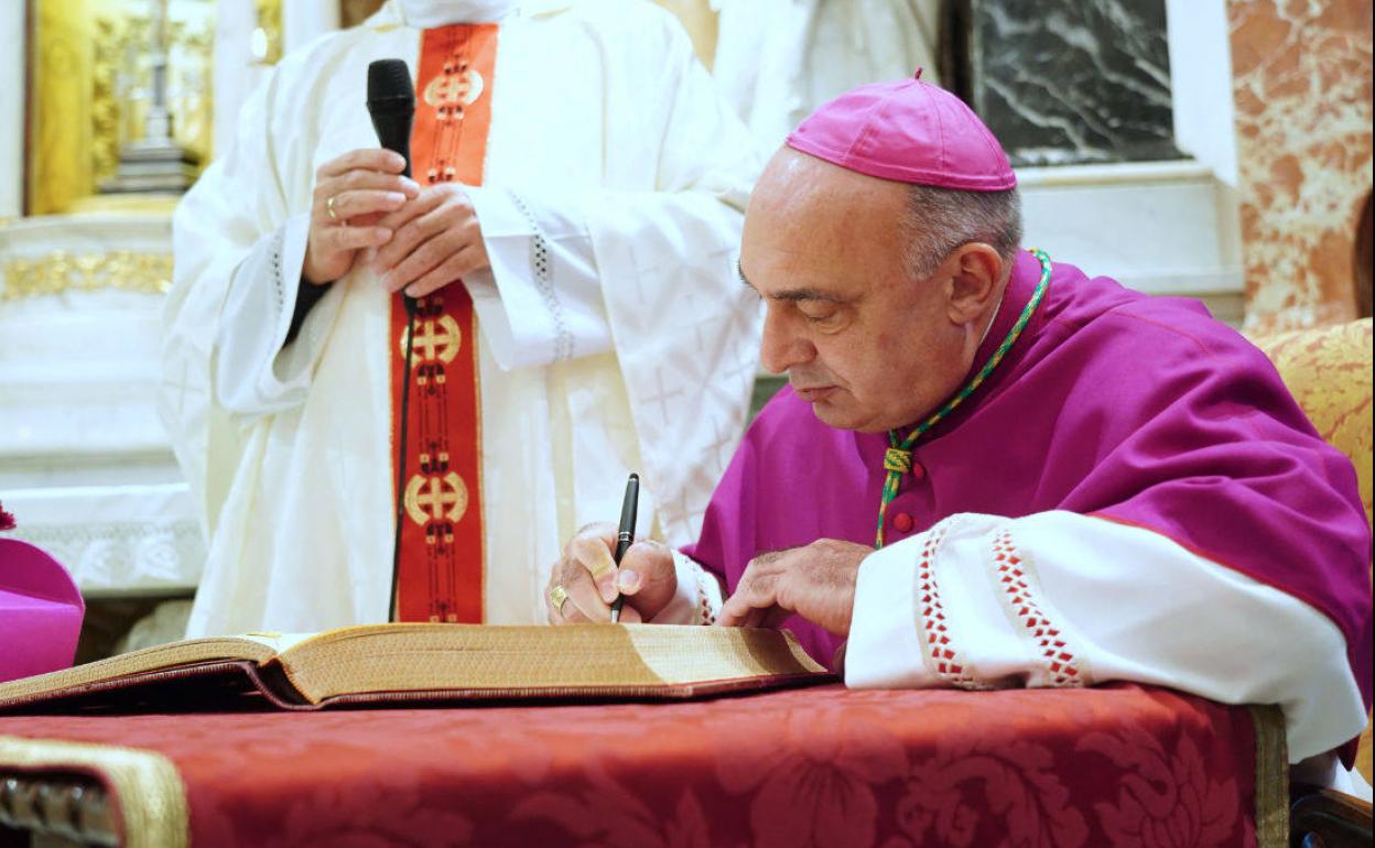 El arzobispo escribe en el Libro de Honor de la Basílica. 