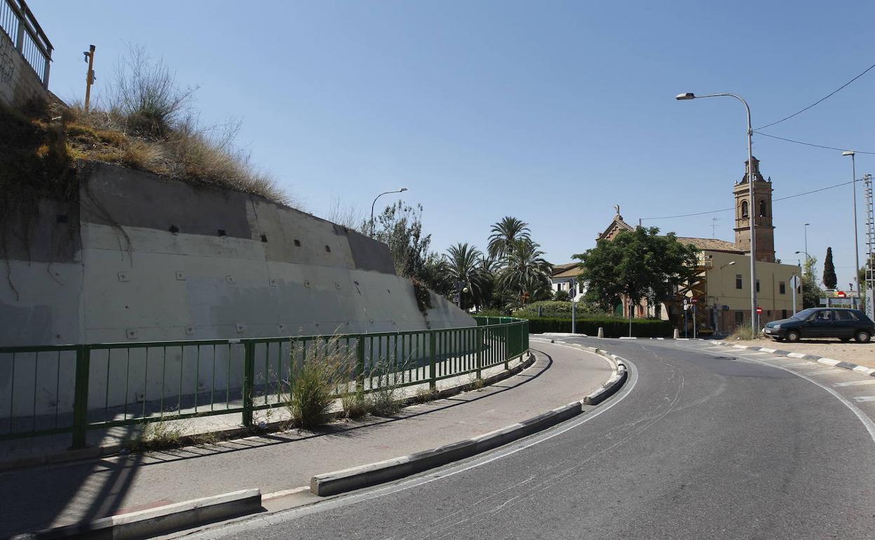 Talud de las vías del tren con la iglesia del barrio de San Isidro al fondo. 