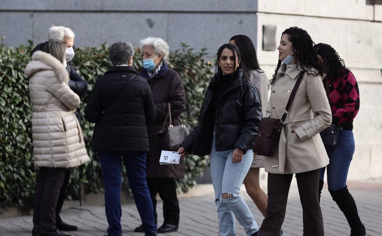 Un grupo de personas caminas por la calle. 