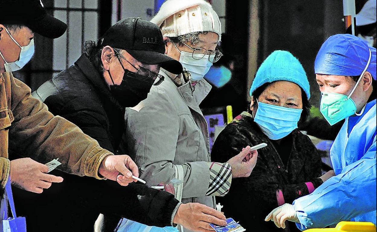 Enfermeros realizan pruebas PCR a los pacientes en la entrada de un hospital de Shanghái, China. 