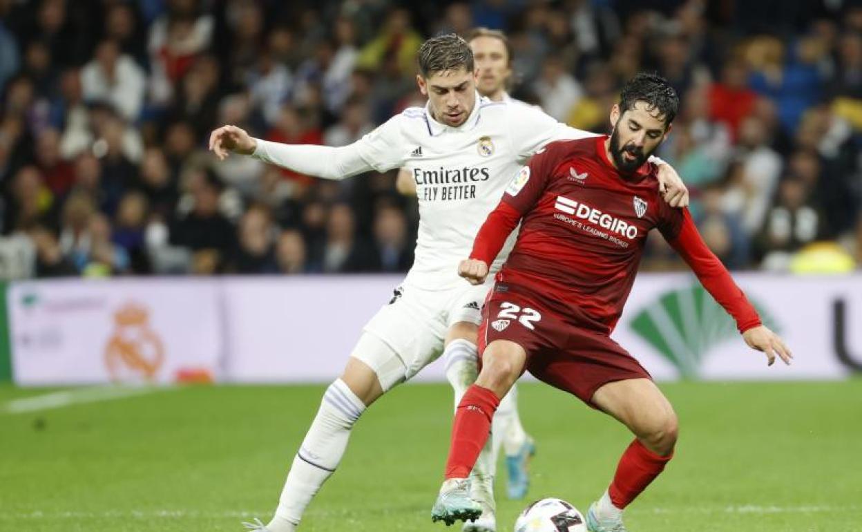 El sevillista Isco Alcarcón disputa un balón con el madridista Fede Valverde. 