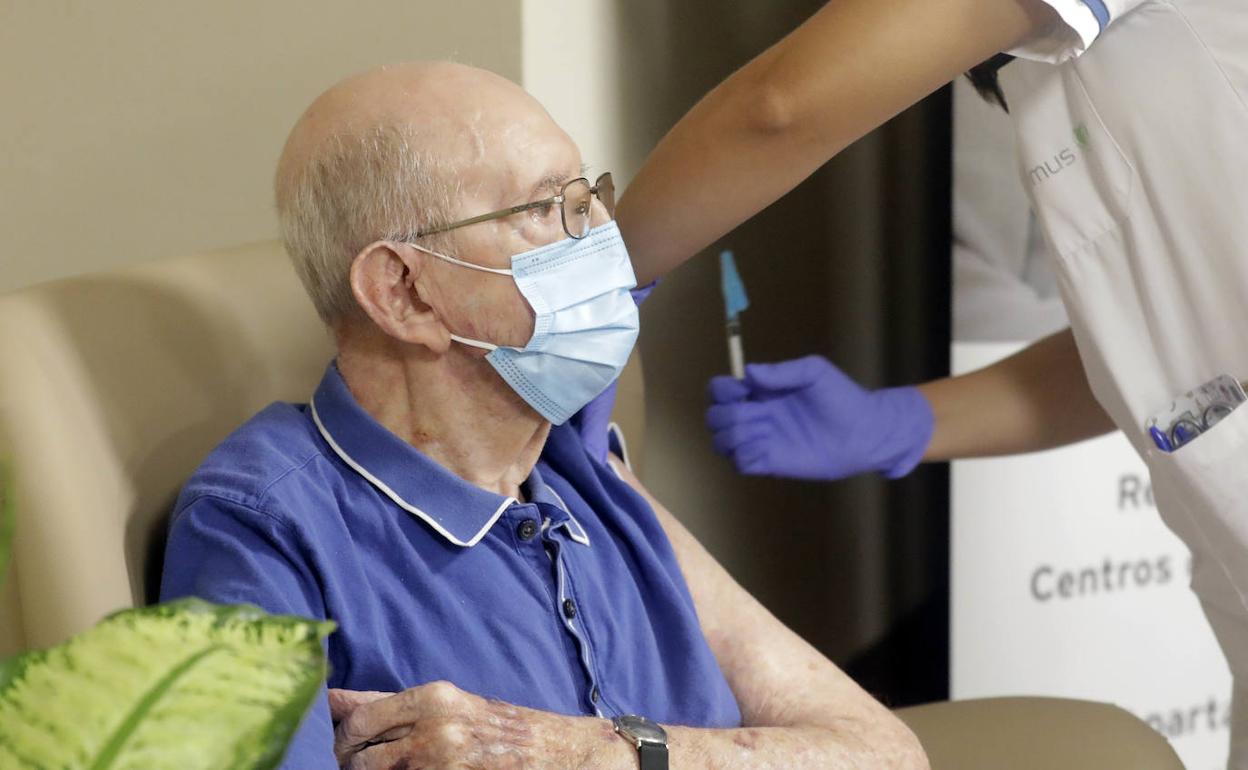 Personal sanitario administra una vacuna a un paciente.