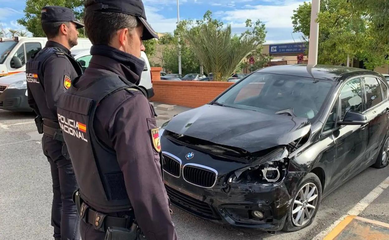 Dos agentes comprueban un coche siniestrado. 