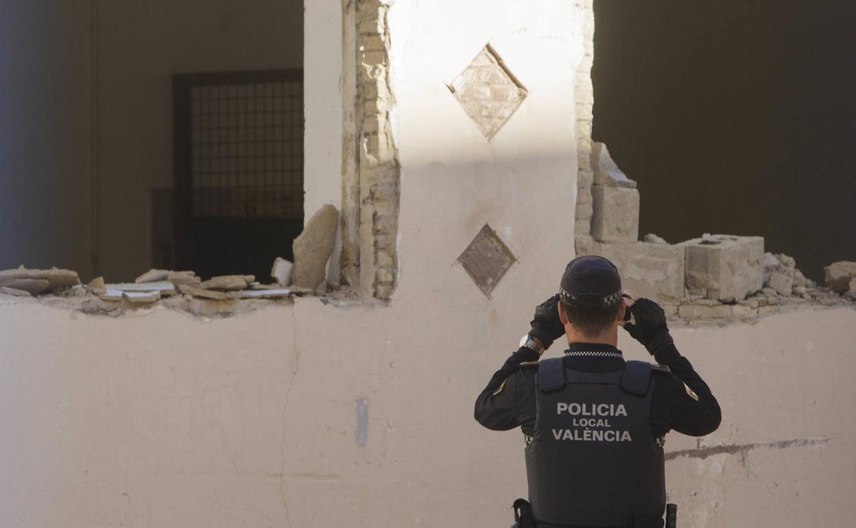 Un policía fotografía los derribos en una de las naves esta semana. 